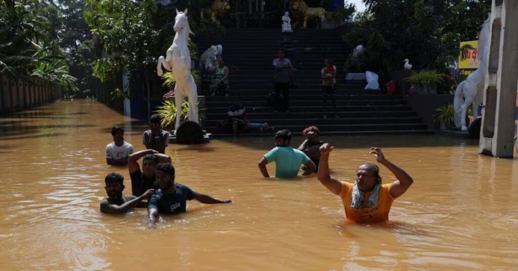 শ্রীলংকার কেলানিয়ায় ঘূর্ণিঝড় ‘ডিটওয়াহ’র পর মানুষ প্লাবিত রাস্তায় হেঁটে যাচ্ছে।
